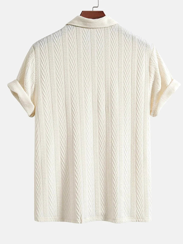 Beige knit polo shirt with structured collar and rolled short sleeves — light neutral tone with subtle pattern and stretch.