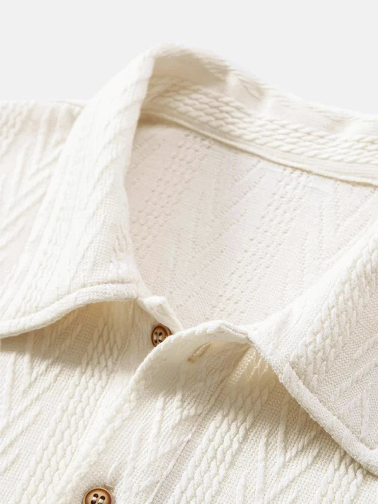 Beige knit polo shirt with structured collar and rolled short sleeves — light neutral tone with subtle pattern and stretch.