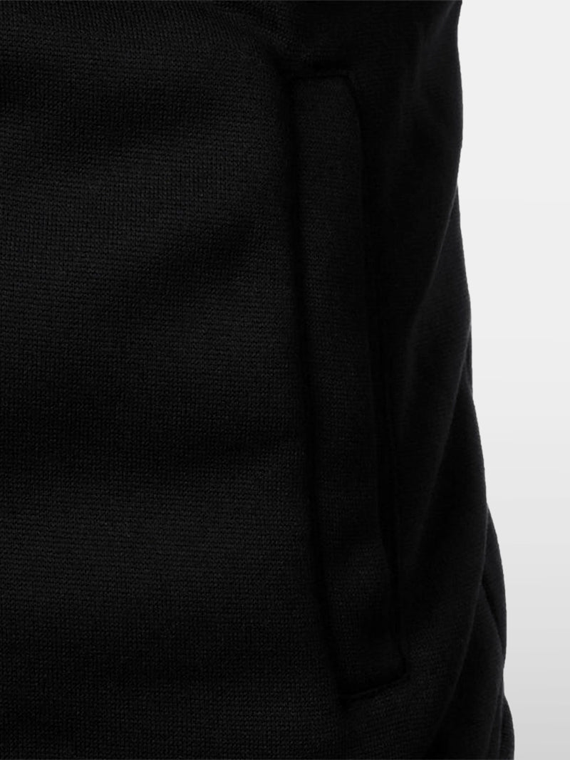 Black knitted zip sweater with structured collar and lined interior — versatile silhouette with subtle authority and discreet comfort.