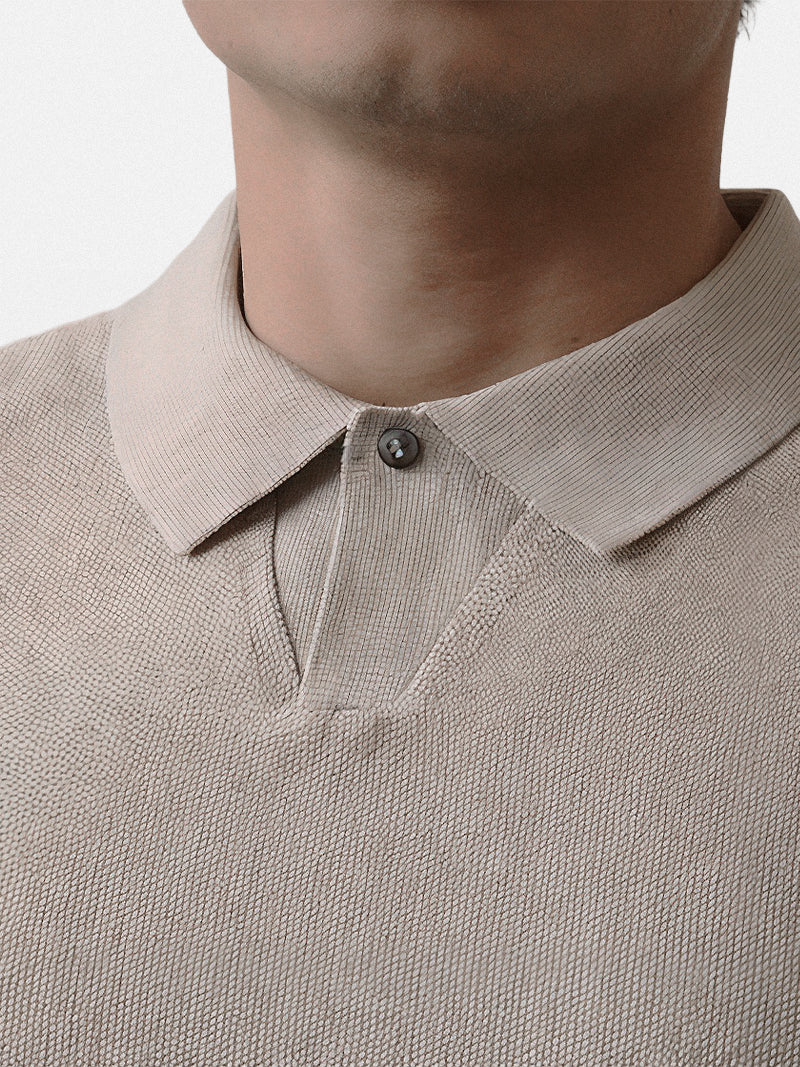 Apricot short sleeve polo with ribbed cuffs and compact knit — warm neutral tone with elegant fit.