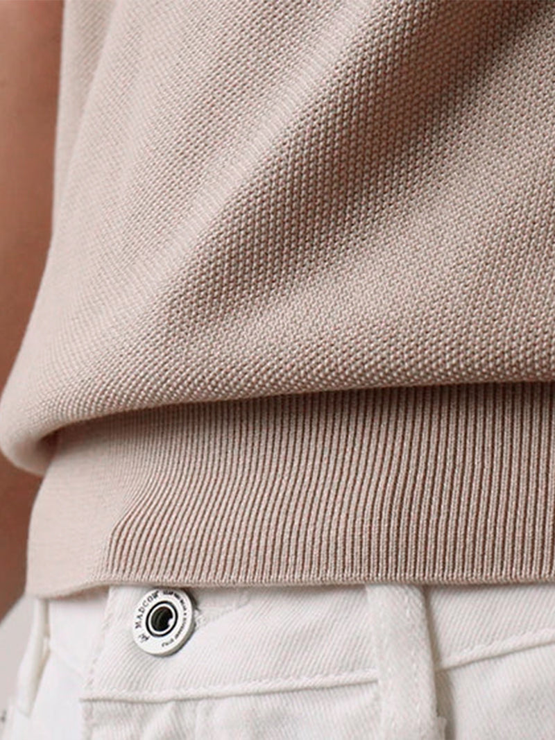 Apricot short sleeve polo with ribbed cuffs and compact knit — warm neutral tone with elegant fit.