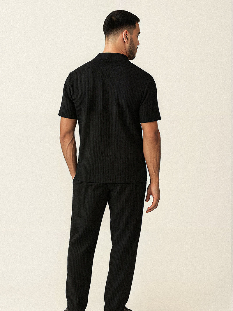 Black striped two-piece set for men with breathable short sleeve shirt and relaxed pants — discreet elegance in a structured silhouette.