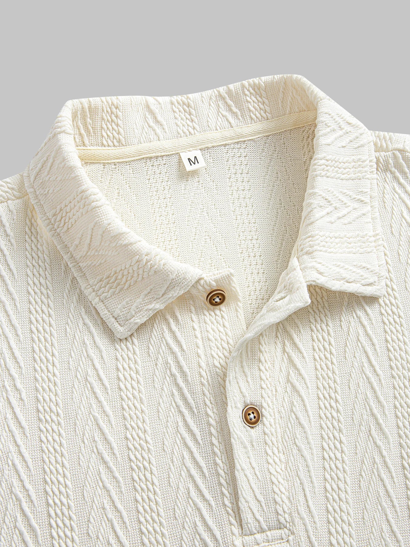Beige knit polo shirt with structured collar and rolled short sleeves — light neutral tone with subtle pattern and stretch.
