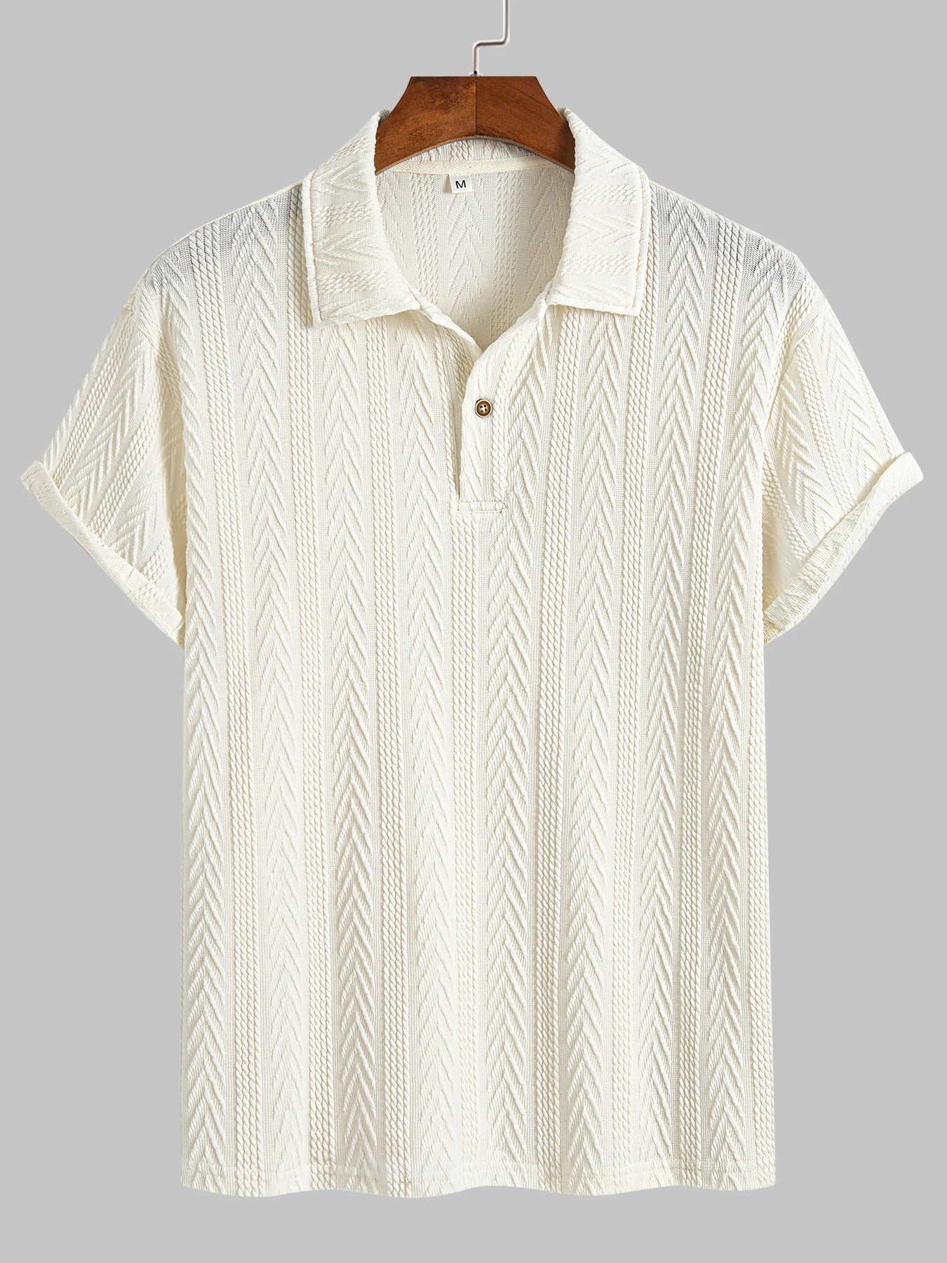 Beige knit polo shirt with structured collar and rolled short sleeves — light neutral tone with subtle pattern and stretch.